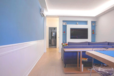 Esempio di un grande soggiorno minimal aperto con libreria, pareti blu, parquet chiaro, parete attrezzata e boiserie