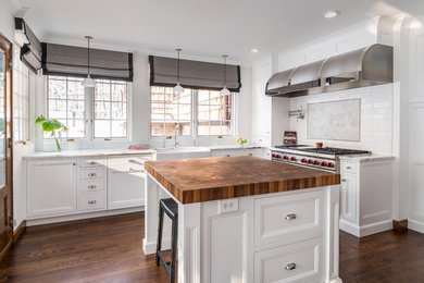 Mid-sized traditional l-shaped separate kitchen in Grand Rapids with a farmhouse sink, recessed-panel cabinets, white cabinets, quartzite benchtops, white splashback, subway tile splashback, stainless steel appliances, medium hardwood floors, with island, brown floor and white benchtop.