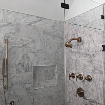 Modern primary bathroom with marble tile, curbless shower and custom vanity