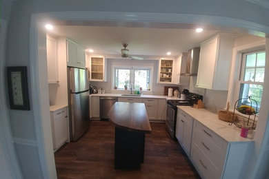 Elegant multicolored floor kitchen photo in New York with shaker cabinets, white cabinets, wood countertops and an island