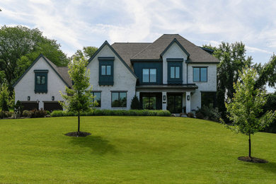 Example of a huge transitional white four-story brick house exterior design in Other with a mixed material roof and a brown roof
