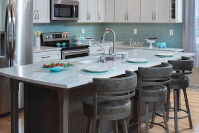 Example of a mid-sized transitional u-shaped eat-in kitchen design in Milwaukee with recessed-panel cabinets, white cabinets, quartz countertops, blue backsplash, glass tile backsplash, an island and white countertops