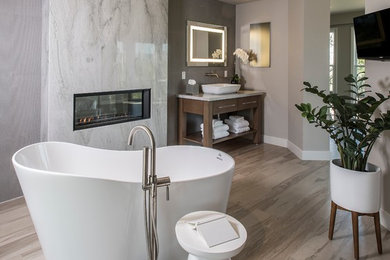 Example of a large trendy master white tile and marble tile vinyl floor and gray floor freestanding bathtub design in Phoenix with open cabinets, dark wood cabinets, gray walls, a vessel sink and white countertops