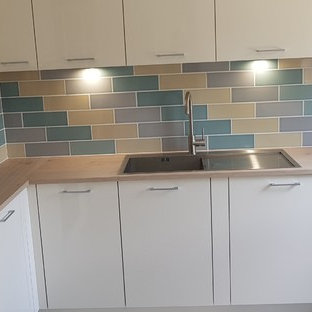 Esempio di una piccola cucina ad U chic chiusa con lavello da incasso, ante a persiana, ante beige, top in laminato, paraspruzzi multicolore, paraspruzzi con piastrelle in terracotta, elettrodomestici bianchi, pavimento in vinile, nessuna isola, pavimento grigio e top marrone