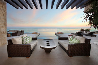 Example of a large trendy backyard stone patio design in Los Angeles with a fire pit and a pergola