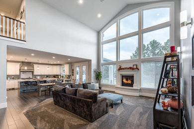 Large transitional formal and open concept dark wood floor and brown floor living room photo in Salt Lake City with gray walls, a standard fireplace, a plaster fireplace and a tv stand