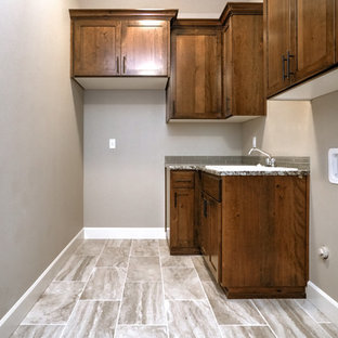 Medium sized traditional laundry cupboard in Portland with a built-in sink, shaker cabinets, dark wood cabinets, granite worktops, beige walls, a stacked washer and dryer, beige floors and multicoloured worktops.