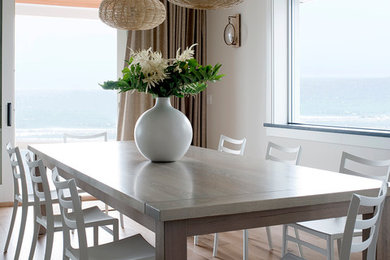 Photo of a beach style open plan dining in Portland Maine with white walls and light hardwood floors.