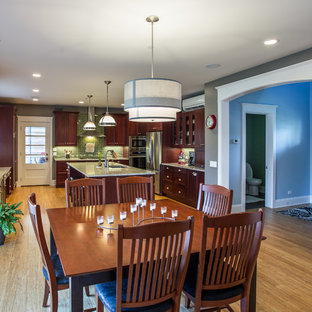 Design ideas for a mid-sized arts and crafts open plan dining in Chicago with grey walls, light hardwood floors, a standard fireplace and a plaster fireplace surround.