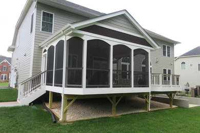 Elegant screened-in back porch photo in DC Metro with decking and a roof extension