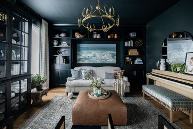Imagen de salón con rincón musical negro tradicional de tamaño medio sin televisor con paredes verdes y suelo de madera clara