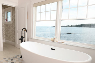 На фото: большая главная ванная комната в морском стиле с отдельно стоящей ванной, мраморным полом и разноцветным полом с
