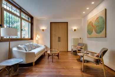 Modelo de sala de estar tradicional renovada grande con paredes blancas, suelo de madera en tonos medios y suelo marrón