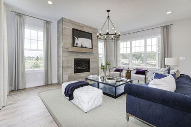 Example of a trendy open concept beige floor and laminate floor living room design in DC Metro with white walls and a standard fireplace