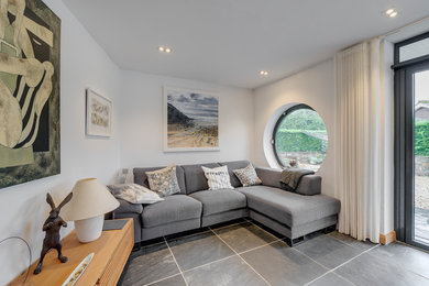 Mid-sized modern open concept living room in Cornwall with white walls, slate floors and grey floor.