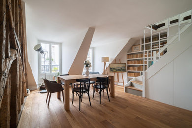 Contemporary open plan dining in Paris with white walls and light hardwood floors.