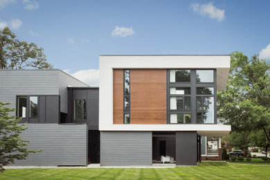 Large minimalist gray split-level wood exterior home photo in Charlotte with a mixed material roof