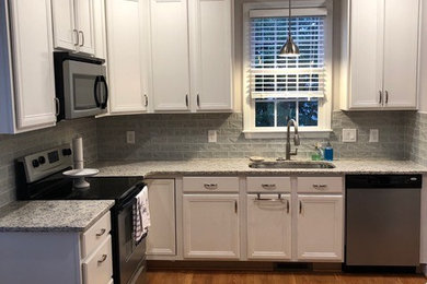 Küche mit Granit-Arbeitsplatte und Rückwand aus Glasfliesen in Raleigh