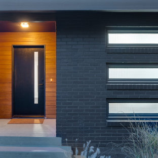 Diseño de puerta principal madera, retro, grande, con paredes marrones, suelo de cemento, puerta simple, puerta negra, suelo gris y madera