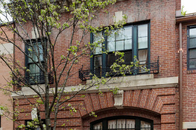 Photo of a mid-sized traditional two-storey brick red exterior in Boston with a flat roof.