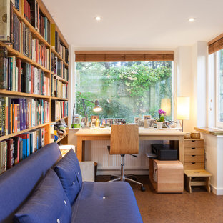Small contemporary home office and library in London with a reading nook, white walls and a freestanding desk.