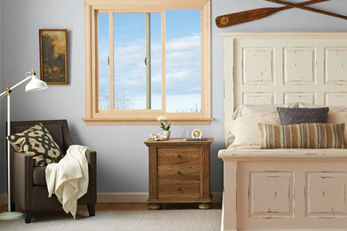 Mid-sized cottage guest medium tone wood floor and brown floor bedroom photo in Portland with gray walls and no fireplace