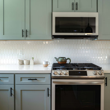 Sage Green Kitchen Cabinets and white geometric tile backsplash