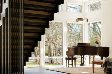 Modernes Musikzimmer mit weißer Wandfarbe, dunklem Holzboden und braunem Boden in Austin