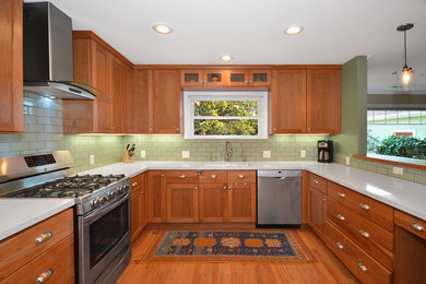 Example of a mid-sized beach style u-shaped medium tone wood floor enclosed kitchen design in San Francisco with shaker cabinets, quartz countertops, no island, a single-bowl sink, medium tone wood cabinets, green backsplash, ceramic backsplash and stainless steel appliances