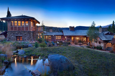 Large mountain style brown two-story mixed siding exterior home photo in Other