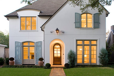 Example of a classic white two-story gable roof design in Houston