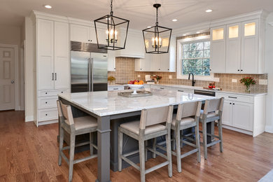 Inspiration for a transitional eat-in kitchen in Chicago with an undermount sink, flat-panel cabinets, white cabinets, quartzite benchtops, beige splashback, porcelain splashback, stainless steel appliances, light hardwood floors, with island, beige floor and white benchtop.