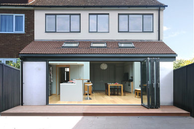 Photo of a small and beige contemporary two floor render and rear house exterior in Essex with a tiled roof and a brown roof.