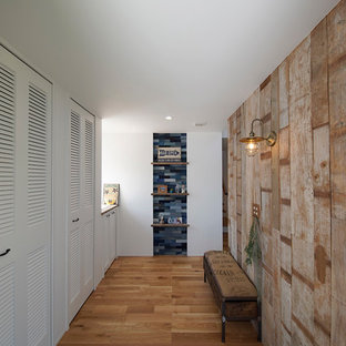 他の地域のビーチスタイルのおしゃれな玄関 (茶色い壁、グレーの床) の写真