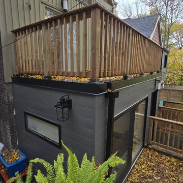 Cedar railing around the roof deck above the dark-clad extension, Toronto
