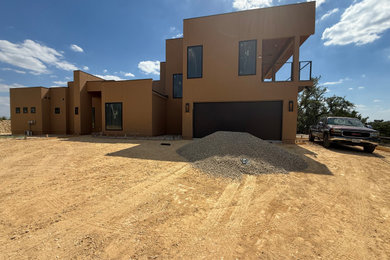 Inspiration for a mid-sized timeless two-story stucco house exterior remodel in Other with a metal roof
