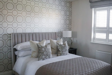 Ejemplo de habitación de invitados moderna grande con paredes beige, moqueta, suelo gris y papel pintado