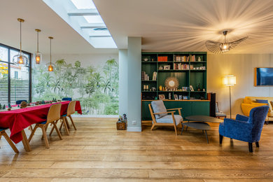 Diseño de sala de estar con biblioteca contemporánea con paredes beige, suelo de madera clara y suelo marrón