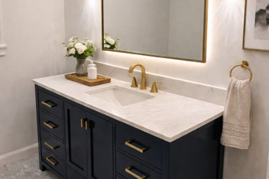 Bathroom - mid-sized porcelain tile, multicolored floor and single-sink bathroom idea in Atlanta with shaker cabinets, blue cabinets, a two-piece toilet, white walls, an undermount sink, marble countertops, white countertops, a niche and a freestanding vanity