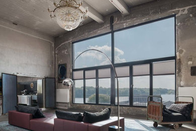 Large industrial open concept living room in Berlin with concrete floors and no fireplace.