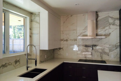 Kitchen - mid-sized modern l-shaped kitchen idea in Calgary with quartz countertops, white backsplash, porcelain backsplash, a double-bowl sink, flat-panel cabinets, white cabinets and an island