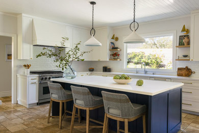 Example of a large transitional l-shaped travertine floor and shiplap ceiling enclosed kitchen design in San Francisco with a drop-in sink, shaker cabinets, white cabinets, quartz countertops, white backsplash, ceramic backsplash, an island and white countertops
