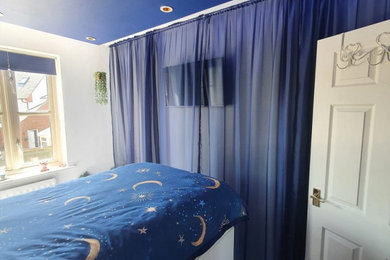Ejemplo de dormitorio infantil moderno pequeño con paredes azules, moqueta, suelo gris y bandeja