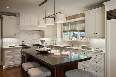 Mid-sized l-shaped dark wood floor and brown floor kitchen photo in Chicago with an undermount sink, recessed-panel cabinets, white cabinets, marble countertops, white backsplash, marble backsplash, paneled appliances and an island