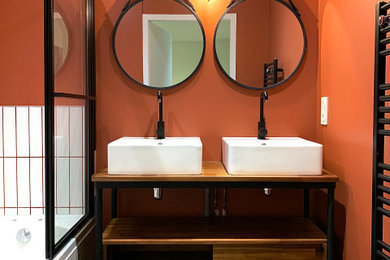 Idée de décoration pour une salle de bain principale sud-ouest américain en bois foncé de taille moyenne avec un placard à porte plane, une baignoire encastrée, un combiné douche/baignoire, WC séparés, un carrelage blanc, des carreaux de céramique, un mur orange, un lavabo posé, un plan de toilette en bois, un sol noir, une cabine de douche à porte battante, un plan de toilette marron, meuble double vasque, meuble-lavabo sur pied et un sol en marbre.