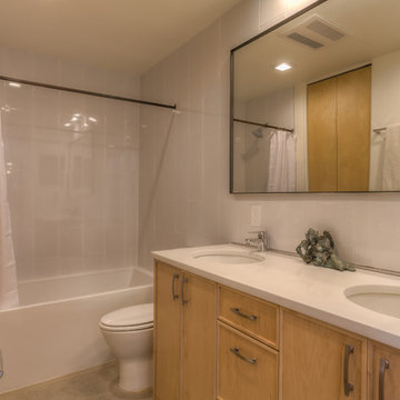 Custom mirror, surround tile walls, laundry off bathroom