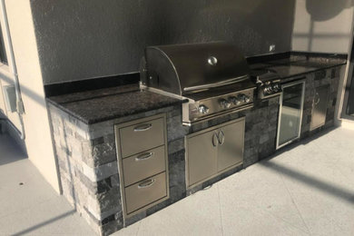 Inspiration for a mid-sized timeless backyard tile patio kitchen remodel in Other with a roof extension