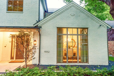 Inspiration for a large transitional white two-story house exterior remodel in Dallas with a gambrel roof and a mixed material roof