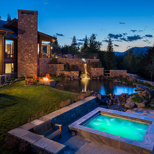 他の地域の巨大な円形ラスティックスタイルのおしゃれなプール (天然石敷き) の写真