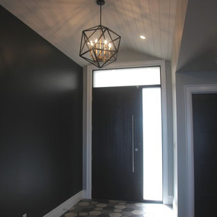 Exempel på en mellanstor eklektisk foajé, med svarta väggar, klinkergolv i porslin, en skjutdörr, mörk trädörr och flerfärgat golv